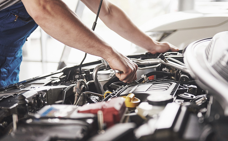 GMC Maintenance Service professional makes adjustments on a GMC SUV engine